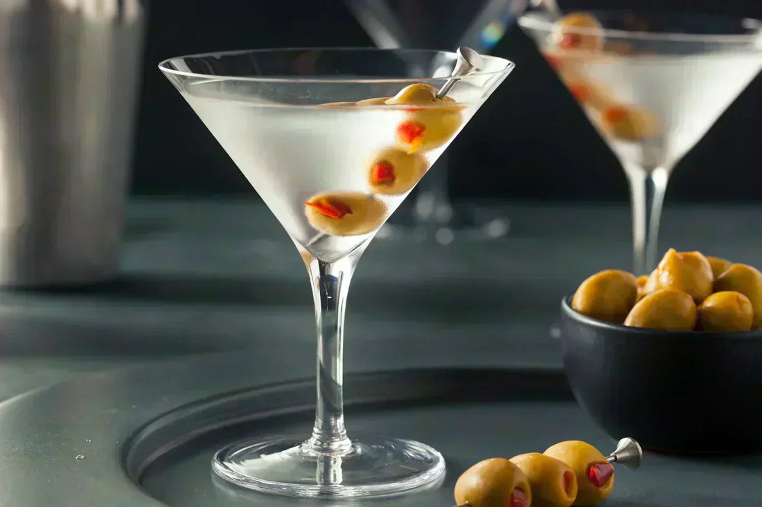 two dry martinis each with 3 olives as garnishes