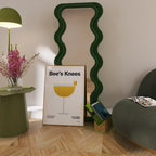 Room interior with a green lamp, framed picture, and wavy green mirror.