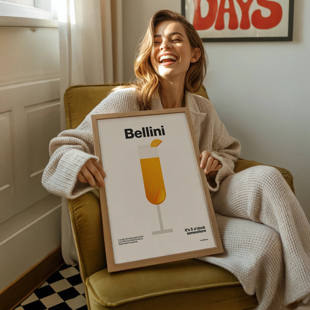 Woman holding a framed picture of a Bellini illustration in a cozy room.