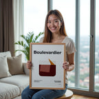 Woman holding a framed poster with 'Boulevardier' design in a living room.