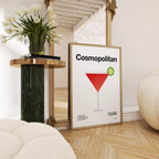 Framed 'Cosmopolitan' cocktail poster on a wall with decorative elements.