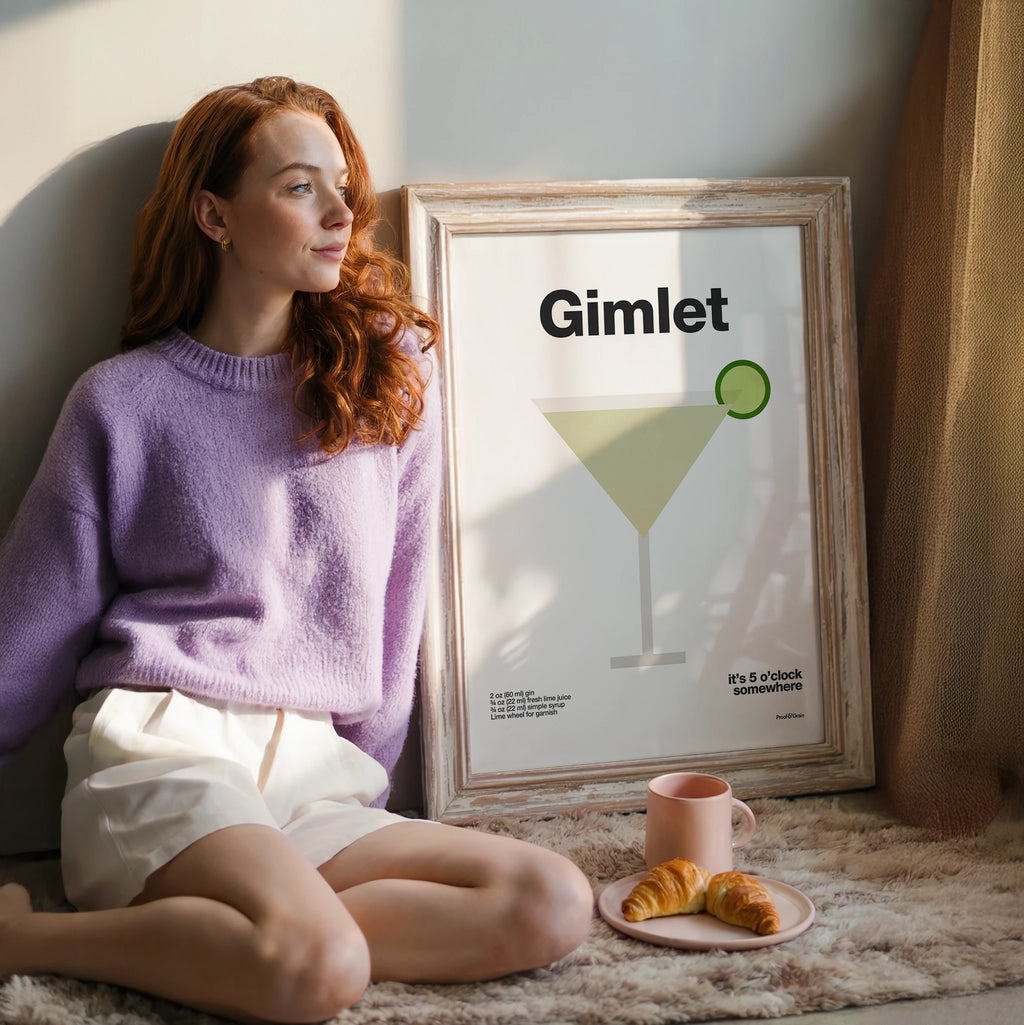 Woman sitting on a couch next to a framed poster with 'Gimlet' branding, surrounded by a plate of food.