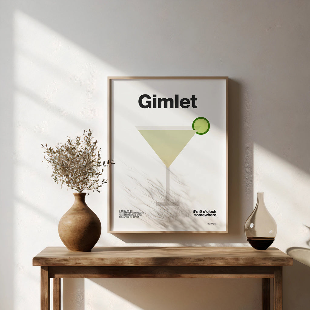 Framed poster with 'Gimlet' design on a wall above a wooden table with decorative items.