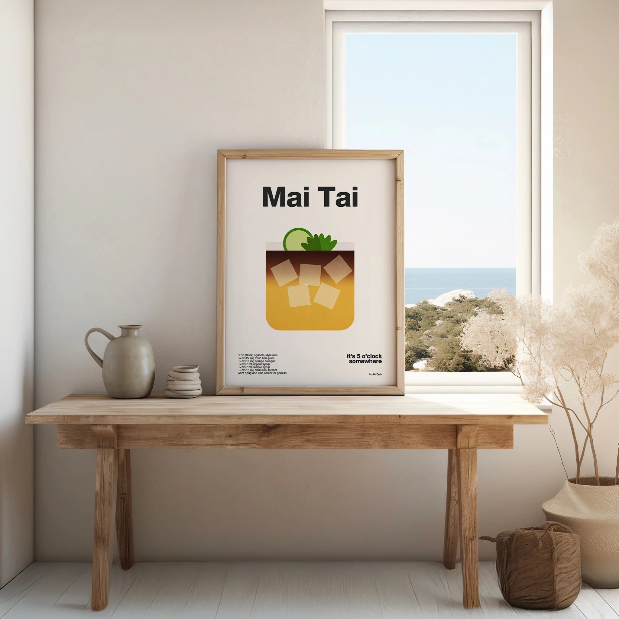 Framed poster of a Mai Tai cocktail on a wooden table with a window view.