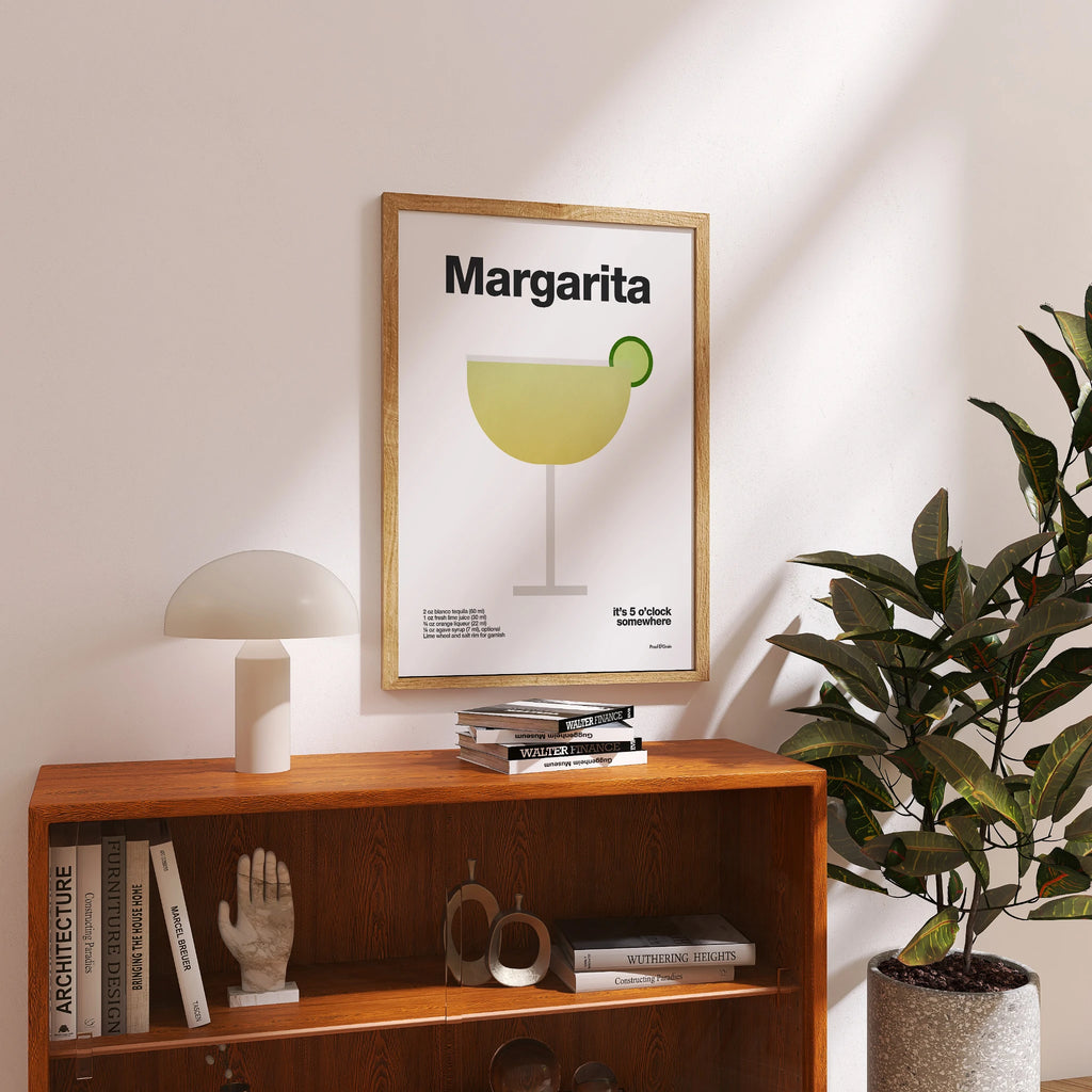 Framed 'Margarita' poster on a shelf with books and decor
