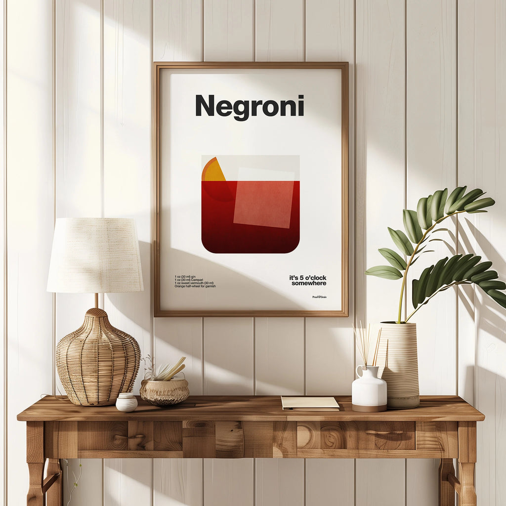 Framed 'Negroni' poster on a wall above a wooden console table with decor items.