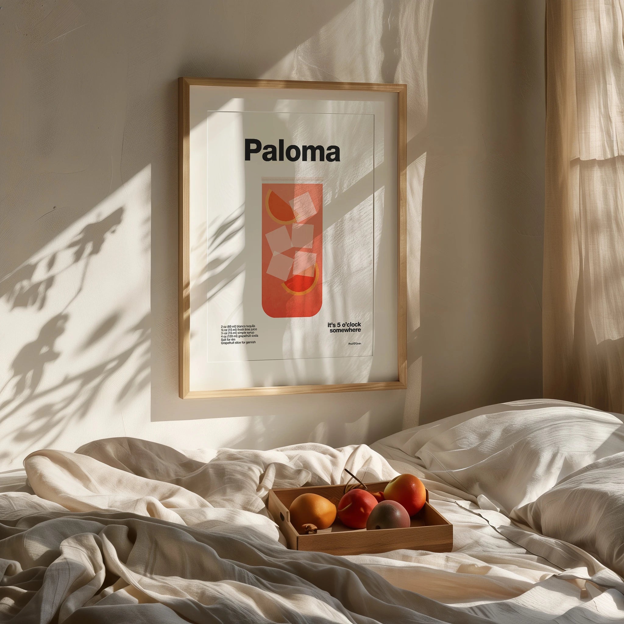 Framed artwork with 'Paloma' on a bed with fruit and blankets